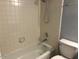 Bright bathroom featuring a tiled shower and tub combo with a white toilet at 15402 N 28Th St # 112, Phoenix, AZ 85032