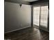 Clean and spacious living room with wood-style flooring and sliding door access to a balcony at 15402 N 28Th St # 112, Phoenix, AZ 85032