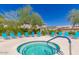 Community hot tub surrounded by lounge chairs and mature landscaping at 16013 S Desert Foothills Pkwy # 1133, Phoenix, AZ 85048