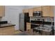 Modern kitchen featuring stainless steel appliances, light wood cabinetry and sleek black marbled countertops at 16013 S Desert Foothills Pkwy # 1133, Phoenix, AZ 85048