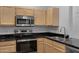 Bright kitchen features stainless steel appliances, light wood cabinetry and black marbled countertop at 16013 S Desert Foothills Pkwy # 1133, Phoenix, AZ 85048