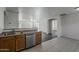 Kitchen with stainless steel dishwasher and double sink, with an open view to the living room at 1615 W Hidalgo Ave, Phoenix, AZ 85041