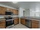 Functional kitchen with stainless steel appliances, wood cabinets, and an open view to the living space at 1615 W Hidalgo Ave, Phoenix, AZ 85041
