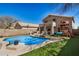Expansive backyard features a refreshing pool, lush lawn, outdoor seating, and play equipment for Gathering fun at 16834 S 20Th Pl, Phoenix, AZ 85048