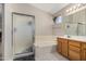 Bright bathroom features a bathtub, walk-in shower with glass door, and wooden cabinets at 16834 S 20Th Pl, Phoenix, AZ 85048