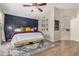 This cozy main bedroom boasts a dark accent wall, decorative rug, and natural light throughout at 16834 S 20Th Pl, Phoenix, AZ 85048