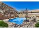 Refreshing pool area with manicured landscaping, offering a relaxing retreat with a natural rock wall backdrop at 16834 S 20Th Pl, Phoenix, AZ 85048