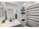 A clean bathroom showcases a white vanity, a black framed mirror, and a shower with a patterned curtain at 16888 W Alice Ave, Waddell, AZ 85355