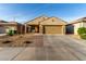 Inviting single-story home featuring a two-car garage, landscaped front yard, and covered porch with seating at 16888 W Alice Ave, Waddell, AZ 85355