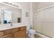 Well-lit bathroom with shower, wooden vanity and view into the Primary bedroom at 16913 W Cortaro Point Dr, Surprise, AZ 85387