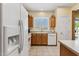Functional kitchen features wood cabinetry, white appliances, and a bright window over the sink at 16913 W Cortaro Point Dr, Surprise, AZ 85387