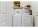 Compact laundry area with shelving and a white washer and dryer at 16913 W Cortaro Point Dr, Surprise, AZ 85387