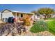 Exterior of a home with desert landscaping, rocks, shrubs, and a covered patio with chairs and a grill at 17200 W Bell Rd # 2221, Surprise, AZ 85374