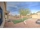 The backyard features an area with grass, playground, and desert landscape at 17526 W Coyote Trail Dr, Goodyear, AZ 85338