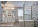 Bright bathroom with a glass-enclosed shower, soaking tub, double sink vanity, and luxury finishes at 17526 W Coyote Trail Dr, Goodyear, AZ 85338