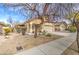 Attractive single-Gathering home featuring desert landscaping, a two-car garage, and mature trees at 17526 W Coyote Trail Dr, Goodyear, AZ 85338