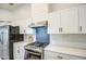 Updated kitchen features stainless steel appliances, white cabinets, and marble countertops at 17526 W Coyote Trail Dr, Goodyear, AZ 85338