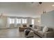 Inviting living room featuring hardwood floors, a modern ceiling fan, and a large sectional sofa at 17526 W Coyote Trail Dr, Goodyear, AZ 85338