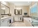 Bathroom featuring double vanities, modern mirrors, separate tub, and beautiful countertops at 18519 N 94Th St, Scottsdale, AZ 85255