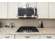 Well-equipped kitchen with stainless steel microwave, gas stove, granite countertops, and tiled backsplash at 18519 N 94Th St, Scottsdale, AZ 85255