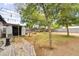 A spacious backyard with a brick patio, shed, fire pit, mature trees, and a gravel area for outdoor enjoyment at 2045 W Orange Dr, Phoenix, AZ 85015