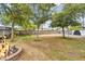 Expansive backyard features a stone fire pit with seating, sand area, and mature trees, ideal for outdoor activities at 2045 W Orange Dr, Phoenix, AZ 85015