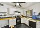 Well-lit kitchen featuring white cabinets, black appliances, a butcher block countertop, and black backsplash at 2045 W Orange Dr, Phoenix, AZ 85015
