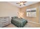Comfortable bedroom with neutral walls, carpeted floor, ceiling fan, and double-door dresser at 20520 E Mockingbird Dr, Queen Creek, AZ 85142