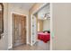 Inviting entryway with a decorative front door opening to a bedroom with a ceiling fan and red comforter at 20520 E Mockingbird Dr, Queen Creek, AZ 85142