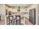 Bright kitchen with white cabinets, stainless steel appliances, an island with seating, and granite countertops at 20520 E Mockingbird Dr, Queen Creek, AZ 85142