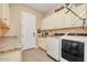 Bright laundry room with overhead cabinets, utility sink, and modern washer and dryer units at 20520 E Mockingbird Dr, Queen Creek, AZ 85142