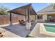 Covered patio featuring built-in grill, counter space, and seating adjacent to the pool at 20520 E Mockingbird Dr, Queen Creek, AZ 85142