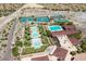 Aerial view of community with pools, tennis courts, and clubhouse amidst desert landscape at 20652 W Clearstream Dr, Buckeye, AZ 85396