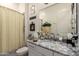 Well-lit bathroom features a granite countertop and yellow patterned shower curtain at 20652 W Clearstream Dr, Buckeye, AZ 85396