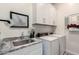 Practical laundry room with granite countertops, utility sink and front loading washer and dryer at 20652 W Clearstream Dr, Buckeye, AZ 85396