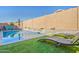 Backyard oasis showcasing a pool, lounge chairs, a well-maintained artificial lawn, and a secure privacy wall at 21090 E Camina Buena Vis, Queen Creek, AZ 85142