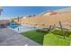 Backyard with a pool, artificial lawn, lounge chairs, a hammock, and privacy wall for entertainment and relaxation at 21090 E Camina Buena Vis, Queen Creek, AZ 85142