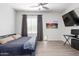 Modern bedroom featuring wood-look floors, a large window, and a comfortable bed at 21090 E Camina Buena Vis, Queen Creek, AZ 85142