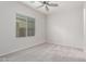 Bright bedroom featuring plush carpet, a ceiling fan, and a large window at 21090 E Camina Buena Vis, Queen Creek, AZ 85142