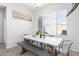 Bright dining area features a modern table with bench seating and a large window with natural light at 21090 E Camina Buena Vis, Queen Creek, AZ 85142