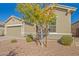 This lovely single-story home has a xeriscaped front yard and a neutral exterior paint scheme at 21090 E Camina Buena Vis, Queen Creek, AZ 85142