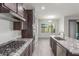 Stylish kitchen featuring stainless steel appliances, granite countertops, a cooktop, and tile flooring at 21090 E Camina Buena Vis, Queen Creek, AZ 85142
