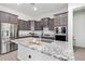 Well-appointed kitchen features stainless steel appliances, dark cabinetry, and a granite-topped center island at 21090 E Camina Buena Vis, Queen Creek, AZ 85142