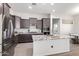 Well-equipped kitchen with granite countertops, stainless appliances, and a large island with sink at 21090 E Camina Buena Vis, Queen Creek, AZ 85142