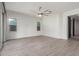Spacious living room offers wood-look tile, neutral walls, and a modern ceiling fan at 21090 E Camina Buena Vis, Queen Creek, AZ 85142