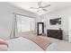 Spacious primary bedroom with large windows, a dresser, and a mounted TV at 21090 E Camina Buena Vis, Queen Creek, AZ 85142