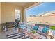 Inviting outdoor patio, featuring comfortable seating, stylish decor, and outdoor cooking area with synthetic grass and pool view at 21090 E Camina Buena Vis, Queen Creek, AZ 85142