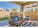 Inviting outdoor patio area, with comfortable seating, stylish decor, and an entertainment area with synthetic grass at 21090 E Camina Buena Vis, Queen Creek, AZ 85142