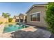 Backyard featuring a private pool, stone patio and artificial turf at 21090 E Camina Buena Vis, Queen Creek, AZ 85142