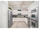 Modern kitchen featuring white cabinets, stainless steel appliances, and wood flooring at 21901 N Sonora Ln, Sun City West, AZ 85375